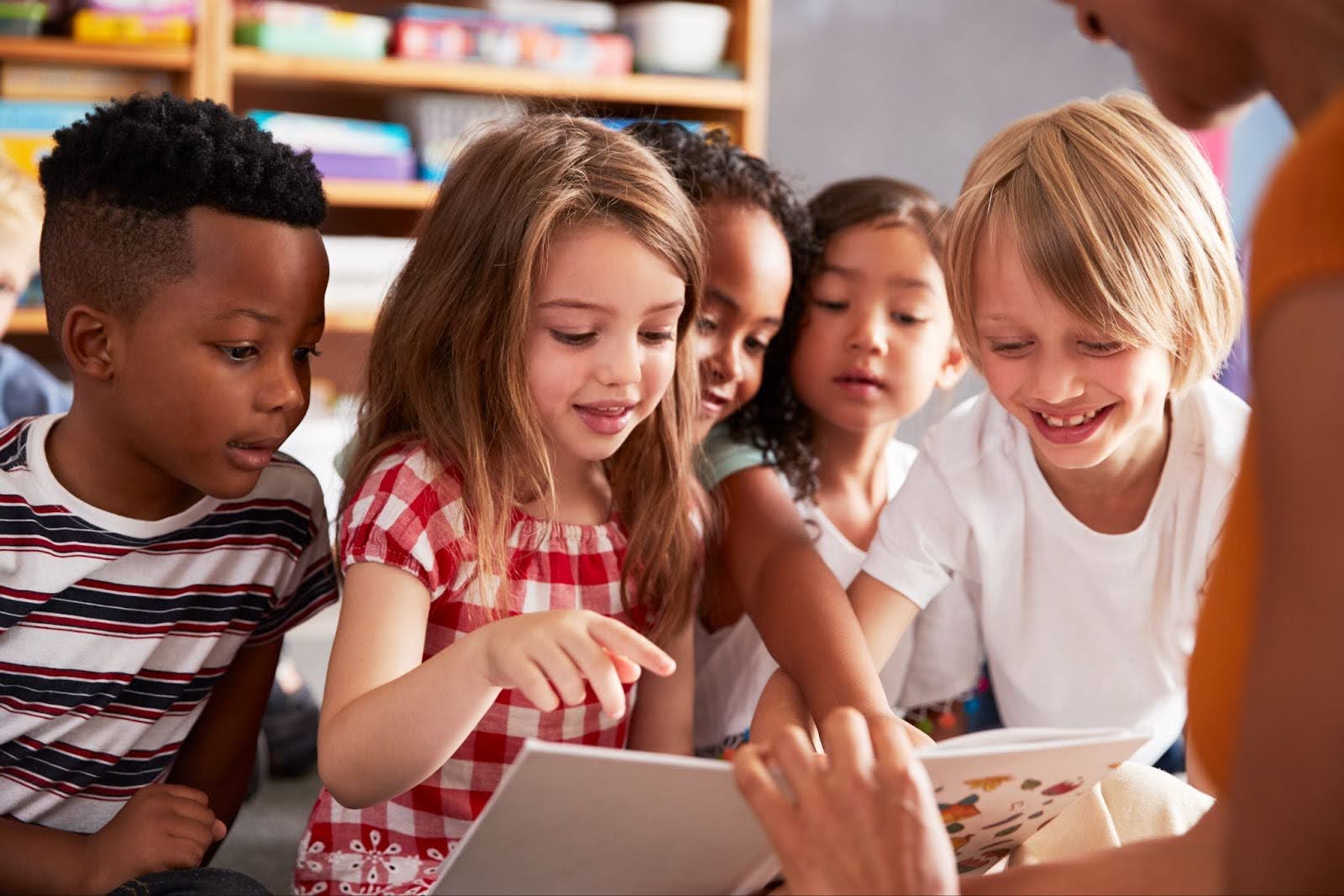 young children pointing at a book