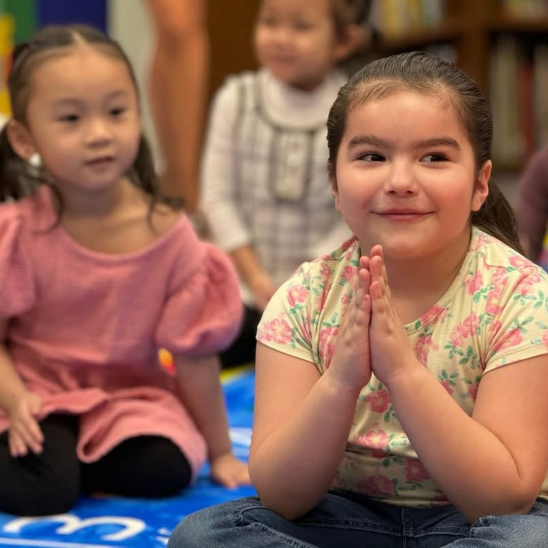 Preschool-aged children sitting together during a group reading activity, listening and engaging during storytime.