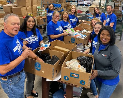 Workplace volunteers assembling community support kits together