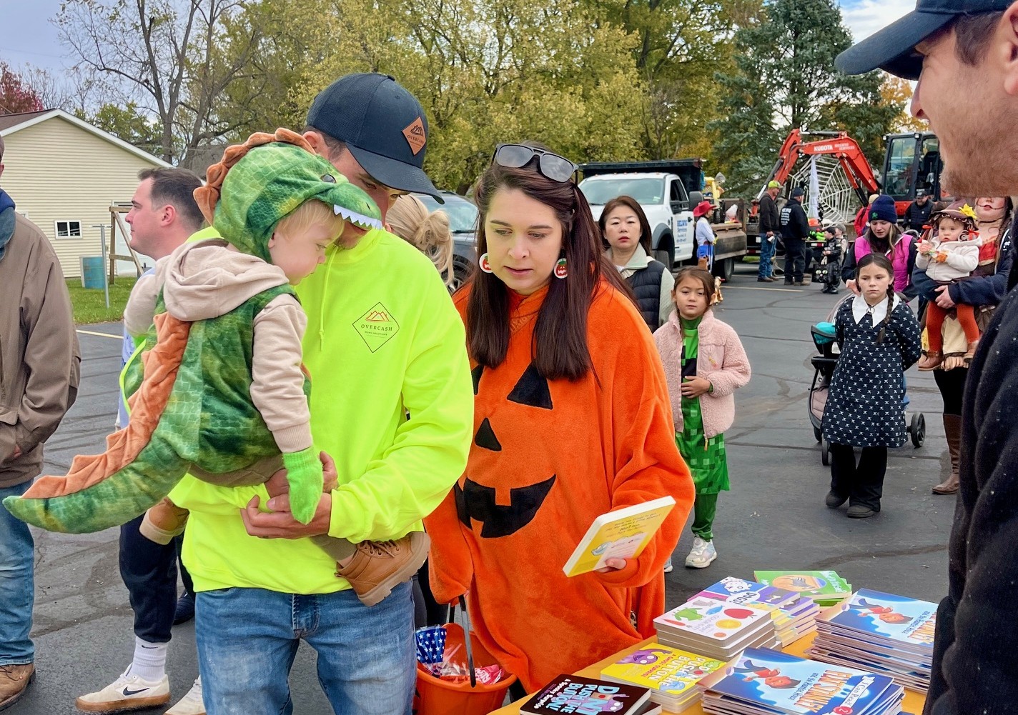 family in costume browses books with Mr. Dan