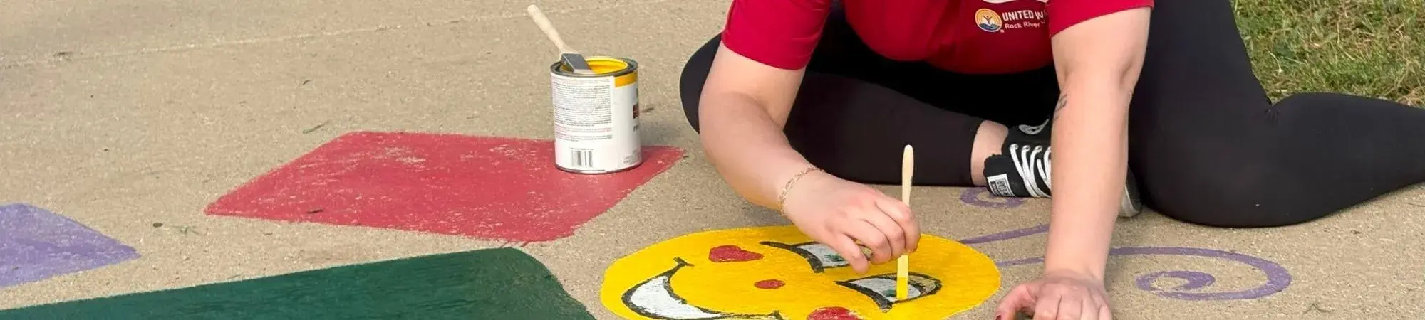 Volunteer painting a smiley face during Day of Caring with United Way Rock River Valley