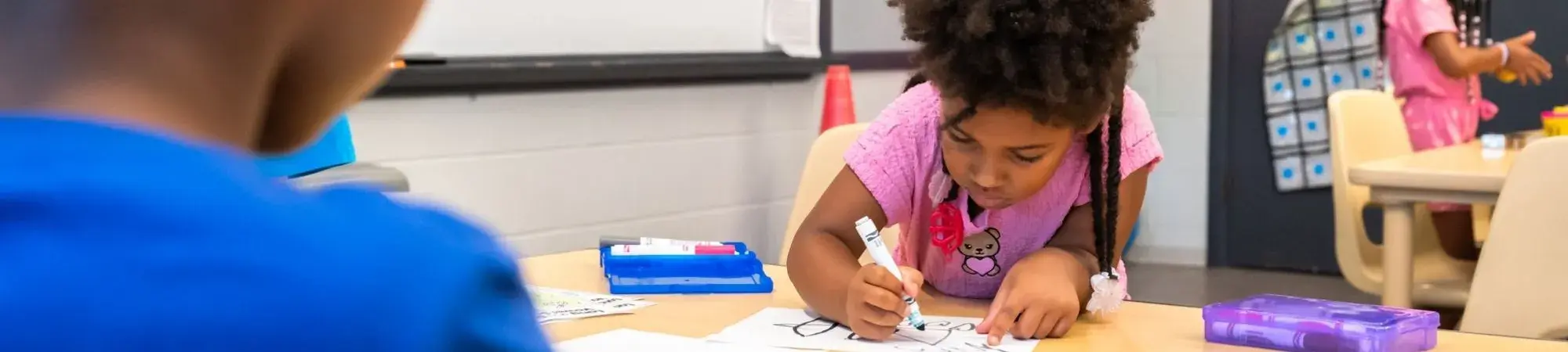 child drawing with markers at the Boys & Girls Club of Rockford