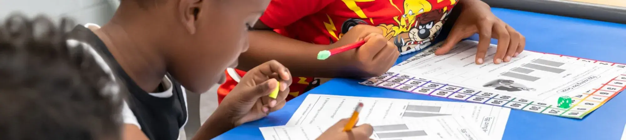 young boys working on worksheets in a classroom setting 
