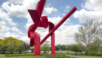 Symbol by Alexander Liberman, a 30-ton red abstract steel sculpture with sweeping curved and cylindrical forms, installed along the banks of the Rock River near the Auburn Street Bridge in Rockford, Illinois. Originally placed on the downtown pedestrian mall in 1978, the work pays homage to Rockford's industrial metal-bending heritage.