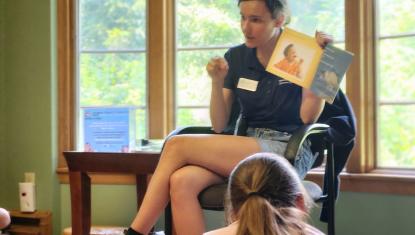 A team member reads illustrated children’s books to a small group during Science Saturdays at Severson Dells, combining literacy with hands-on science learning.